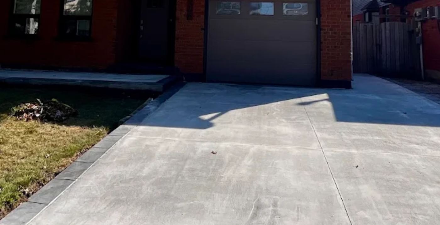 Concrete driveway running to an attached garage